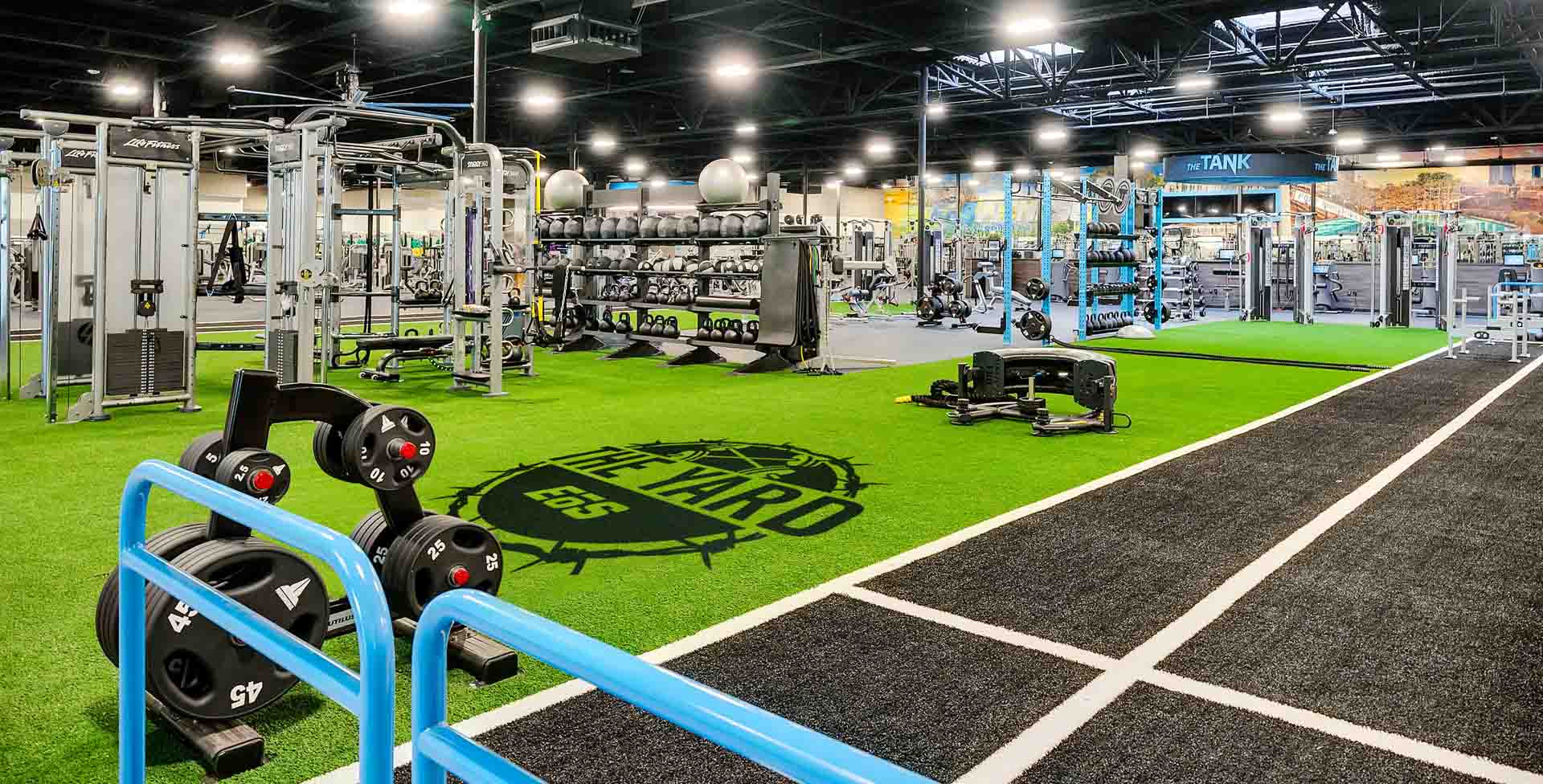 a large indoor shot of an eos branded box gym showing indoor turff and equipment